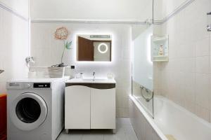 a bathroom with a washing machine and a sink at Apartamento Mar-colina-sol in Carvoeiro