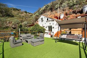 a patio with chairs and a gazebo on the grass at Casa Cueva in Teror