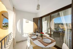 a room with a table with two sinks and a balcony at Apartamento Mar-colina-sol in Carvoeiro