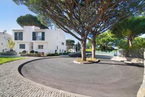 a circular driveway in front of a white house at Bia in Almancil