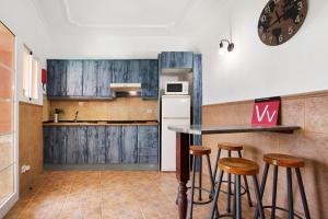 a kitchen with wooden cabinets and bar stools at Casa Doña Margarita in Tuineje +15 photos