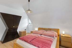 a bedroom with a large bed with pink sheets at Ferienwohnung Ruhepol, 75qm in Vellmar