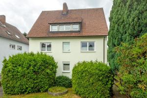 a white house with bushes in front of it at Ferienwohnung Ruhepol, 75qm in Vellmar
