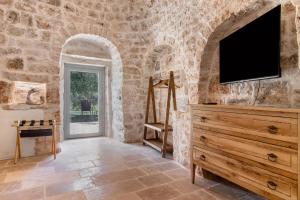 a living room with a tv and a dresser at Trulli House in Putignano