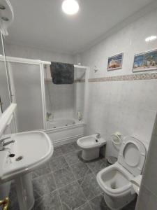 a white bathroom with a toilet and a sink at O Son in Cee