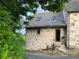 a small stone house with two windows on it at Le Chant du Grillon in Le Nayrac