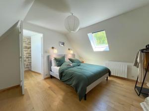 a bedroom with a bed with green sheets and a window at Le Chant du Grillon in Le Nayrac