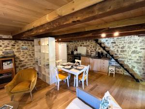 a kitchen and dining room with a table and chairs at Le Chant du Grillon in Le Nayrac