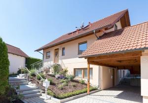 a house with a wooden roof and a pathway at Ferienwohnung Lauser Ug in Herdwangen-Schönach