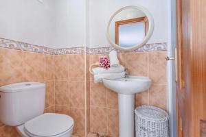 a bathroom with a toilet and a sink and a mirror at Ático La Estrella in Tejina de Isora +27 photos