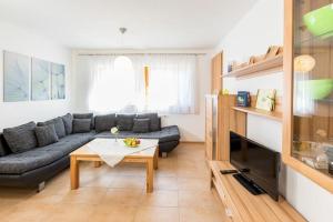 a living room with a couch and a table at Ferienwohnung Lauser Ug in Herdwangen-Schönach