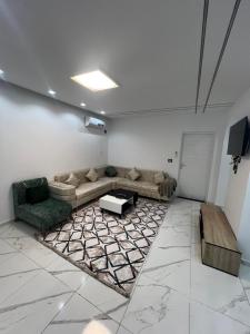 a living room with a couch and a rug at Villa charme in Awlād ‘Umar