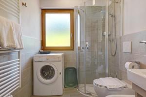 a bathroom with a washing machine and a shower at Schererhof Morgenrot in Castelrotto +29 photos