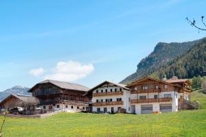 a large building on a hill with mountains in the background at Schererhof Morgenrot in Castelrotto
