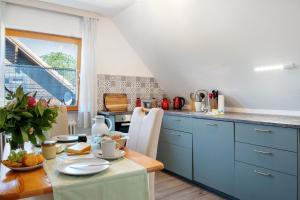 a kitchen with blue cabinets and a wooden table at Ferienwohnung Lisa in Behrensdorf
