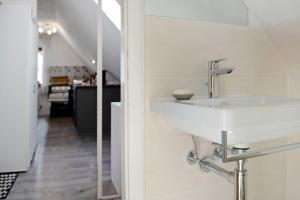a white bathroom with a sink and a hallway at Ferienwohnung Lisa in Behrensdorf +18 photos