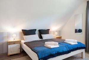 a bedroom with a large bed with blue blanket at Ferienwohnung Lisa in Behrensdorf