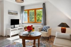 a living room with a vase of flowers on a table at Ferienwohnung Lisa in Behrensdorf