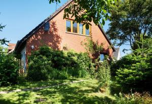 a brick house with a yard in front of it at Ferienwohnung Lisa in Behrensdorf