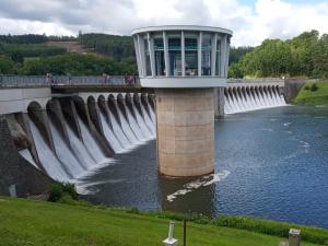 a dam with a building on top of a bridge over water at Ferienwohnungen Schimsheimer Rhode in Olpe
