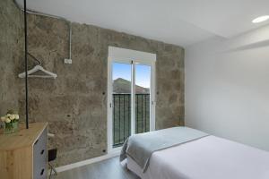 a bedroom with a bed and a window at El Alpendre in Moya