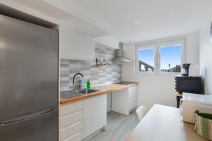 a kitchen with white cabinets and a sink and a window at El Alpendre in Moya +26 photos