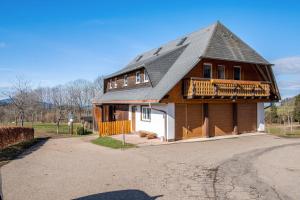ein großes Holzhaus mit Mansarddach in der Unterkunft Brosihof in Erlenbach