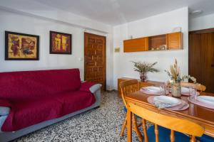 a living room with a red couch and a table at Llúria 51 in Oliva
