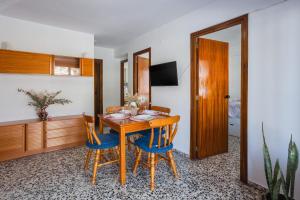 a dining room with a wooden table and blue chairs at Llúria 51 in Oliva