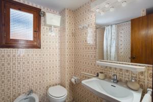 a bathroom with a toilet and a sink and a mirror at Llúria 51 in Oliva +16 photos