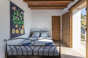 a bedroom with a bed and a painting on the wall at Finca el Cerrillo Competa in Cómpeta +17 photos