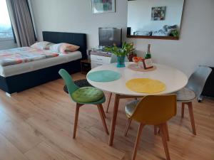 a room with a table and chairs and a bed at Appartment Panoramablick in Oberteuringen +8 photos