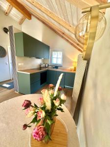 a vase of flowers on a table in a kitchen at Aubrac-Biohof Königshainer Berge in Königshain
