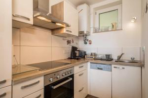 a kitchen with white cabinets and a sink at Appartment Panoramablick in Oberteuringen