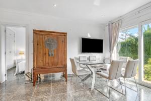 a dining room with a table and chairs and a television at Bohemia in Jávea