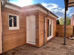 a small wooden house with a door on a brick patio at Apartment am Seefischmarkt in Kiel