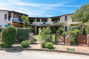 a house with a gate in front of a yard at Appartamento in centro Sole e Mare in Porto San Paolo