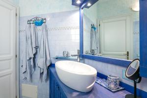 a blue and white bathroom with a sink and a mirror at Appartamento in centro Sole e Mare in Porto San Paolo +18 photos