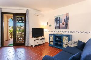 a living room with a blue couch and a television at Appartamento in centro Sole e Mare in Porto San Paolo