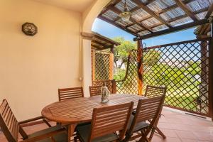 a wooden table and chairs on a patio at Appartamento in centro Sole e Mare in Porto San Paolo