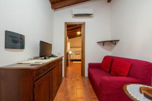 a living room with a red couch and a television at Agata House in Muravera