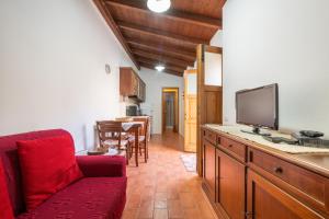 a living room with a red couch and a flat screen tv at Agata House in Muravera