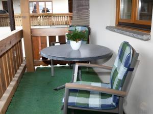 a table and chair on a balcony with a plant at Scharbachhof in Glottertal