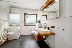 a bathroom with a sink and a washing machine at Eifel-resort in Waxweiler +16 photos