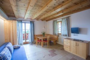 a living room with a table and a tv at Kaserhof in Soprabolzano