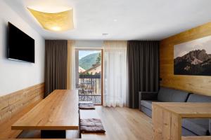 a living room with a table and a couch at Villa Kriendl Nr 4 Dreifinger in Valdaora