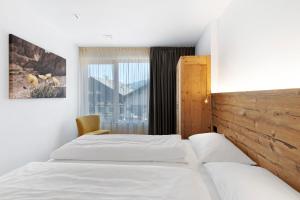 a hotel room with two beds and a window at Villa Kriendl Nr 4 Dreifinger in Valdaora