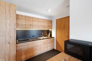 a kitchen with wooden cabinets and a sink at Villa Kriendl Nr 4 Dreifinger in Valdaora