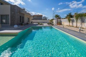 a swimming pool in front of a house at Villa Sele Fontanebianche - Sud in Fontane Bianche