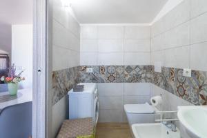 a bathroom with a toilet and a sink and a tub at Villa Sele Fontanebianche - Sud in Fontane Bianche +15 photos